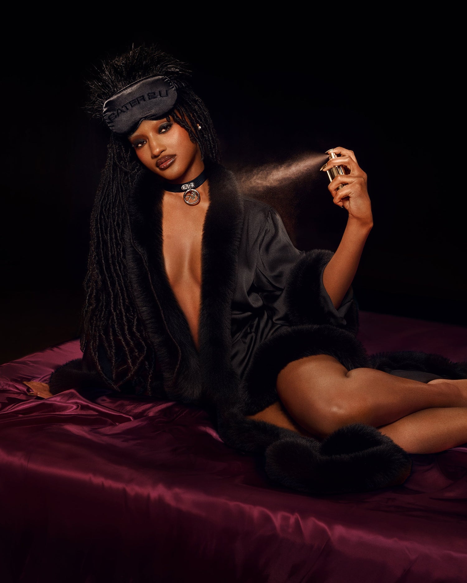CÉ LUMIÈRE BODYGUARD lifestyle shot featuring black robe, sleep mask, choker, and perfume spray